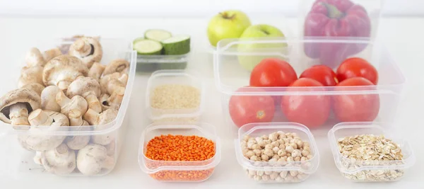 Storage of vegetarian food in plastic containers. A healthy diet with vegetables, fruits, cereals and legumes. Order in the kitchen concept. Banner image