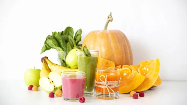 Sonbahar sebze ve meyve smoothies kabak, ıspanak, muz, ahududu ve elma yanında beyaz zemin üzerinde. Diyet, detoks ve vejetaryen yiyecekler
