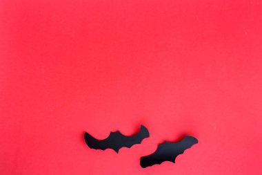 Kırmızı bir arka plan üzerinde siyah yarasalar. Cadılar Bayramı dekorasyon konsepti. Üstten görünüm, düz yatıyordu, kopya alanı