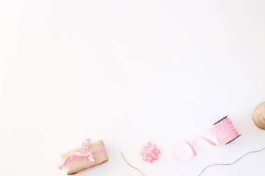 Kraft Kağıt Noel yılbaşı hediyesi bir şerit şerit ve bir yay skein yanında beyaz bir arka plan üzerinde ile dekore edilmiştir. Arka plan kopya alanı. Üstten görünüm, düz yatıyordu