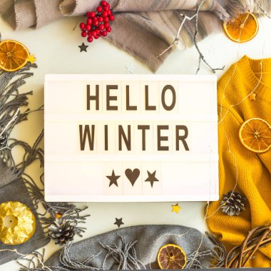 Merhaba kış. Dikdörtgen dekoratif lamba kış kadın kazak ve dekorasyonu - mumlar, portakal, yıldızlar arasında üzerinde siyah harflerle yazılmış. Üstten görünüm, düz yatıyordu