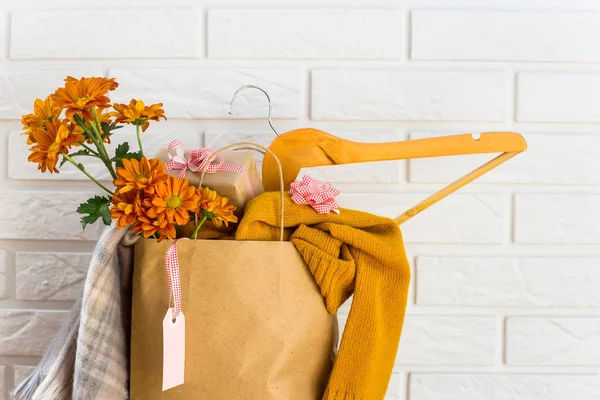 Crafting package with women\'s purchases on a black Friday, filled with clothes, cosmetics, flowers. Near the white brick wall. Discounts black friday concept
