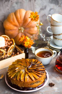 Kuru üzümlü kek Sonbahar dekorasyonu - kabak, mum, portakal ve sarı kasımpatı arasında dilimlenmiş erik ile dekore edilmiştir. Rustik tarzı. Kendinizi evinizde gibi hissedeceğiniz rahat natürmort