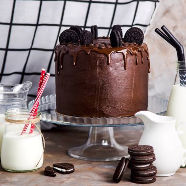 Çikolatalı kek kurabiye gemiler yanında kurabiye gri bir arka plan üzerine bolca süt ile arasında bir cam stand ile dekore edilmiştir. Gurme pasta kavramı