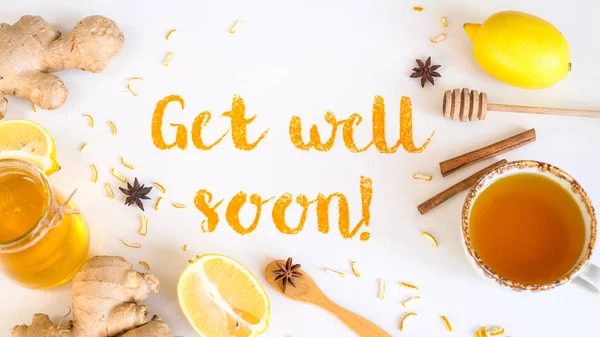 Get well soon - written from ground turmeric on a white background among the products for the treatment of common cold - lemon, honey, ginger
