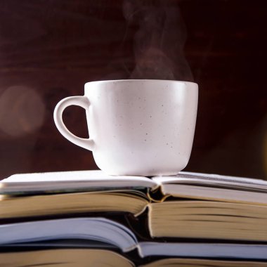 Beyaz bir bardak çay ile açık yığın kitap üzerinde olduğunu. Öğrenme, okuma ve sevgi edebiyat kavramının
