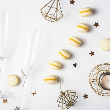 Şampanya bardağı yanında beyaz zemin üzerine sarı limon macaroons. Festival gurme Noel Aperatif. Üstten görünüm, düz yatıyordu