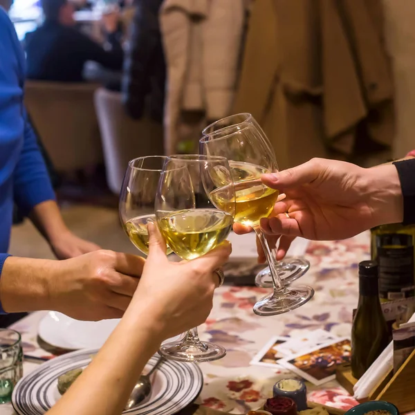 在一群朋友或家人正在吃饭的餐馆里 桌子上的杯中白葡萄酒 — 图库照片