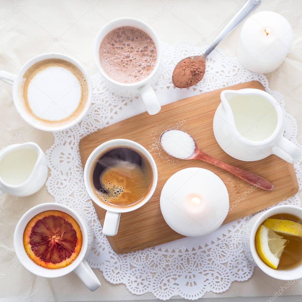 Several different hot drinks on the white table - coffee shop menu