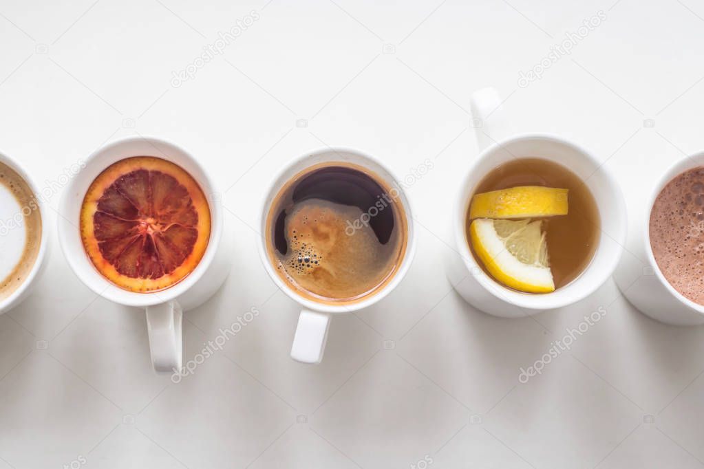 Several different hot drinks on the white table - coffee shop menu