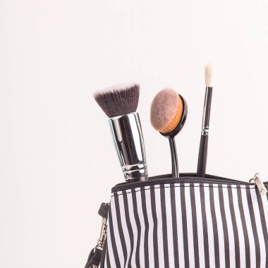 Siyah ve beyaz arasında makyaj kozmetik çantası beyaz bir arka plan üzerinde fırçalar. Minimalist ve şık kozmetik