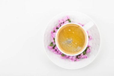 Beyaz fincan kurutulmuş çiçek pembe çiçekli kahve beyaz bir tablo. Minimalizm. Üstten Görünüm, düz yatıyordu