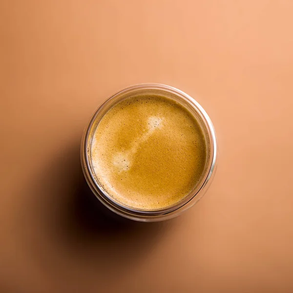 Café negro con espuma en copas modernas sobre un fondo liso —  Fotos de Stock