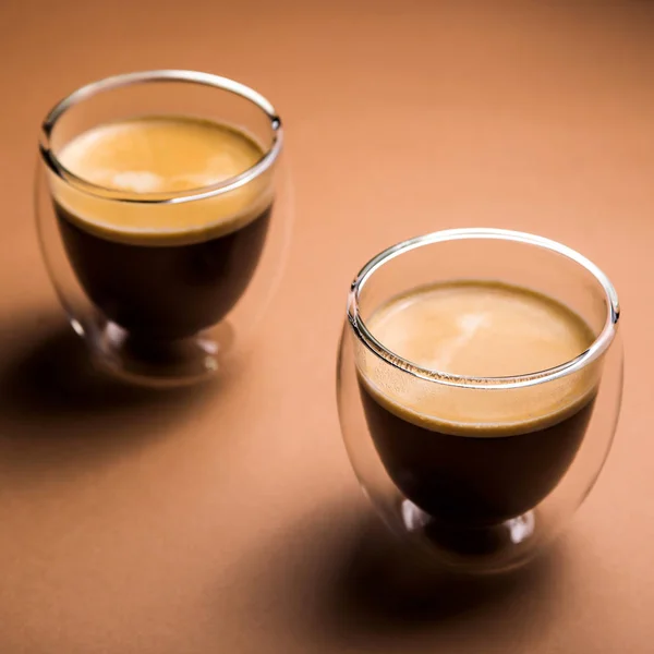 黑咖啡与现代杯泡沫，在纯平的背景 — 图库照片