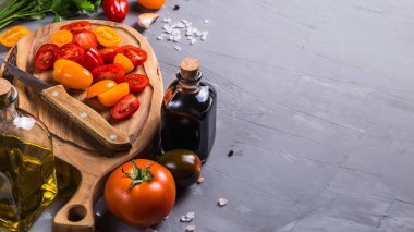 Gri bir arka plan üzerinde sebze yemek pişirmek için olgun domates