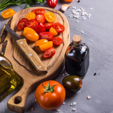 Gri bir arka plan üzerinde sebze yemek pişirmek için olgun domates