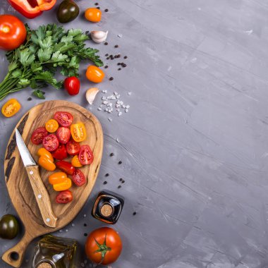 Gri bir arka plan üzerinde sebze yemek pişirmek için olgun domates