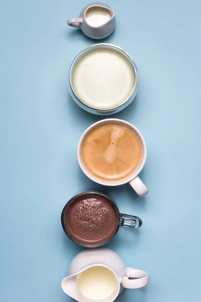 Café, cacao et matcha aux crèmes blanches de lait sur fond bleu — Photo