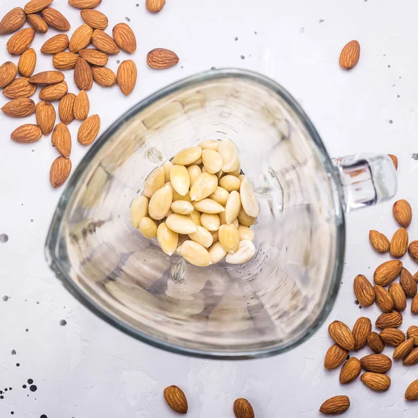Süt yapmak için bir blender bir cam kase içinde soyulmuş badem