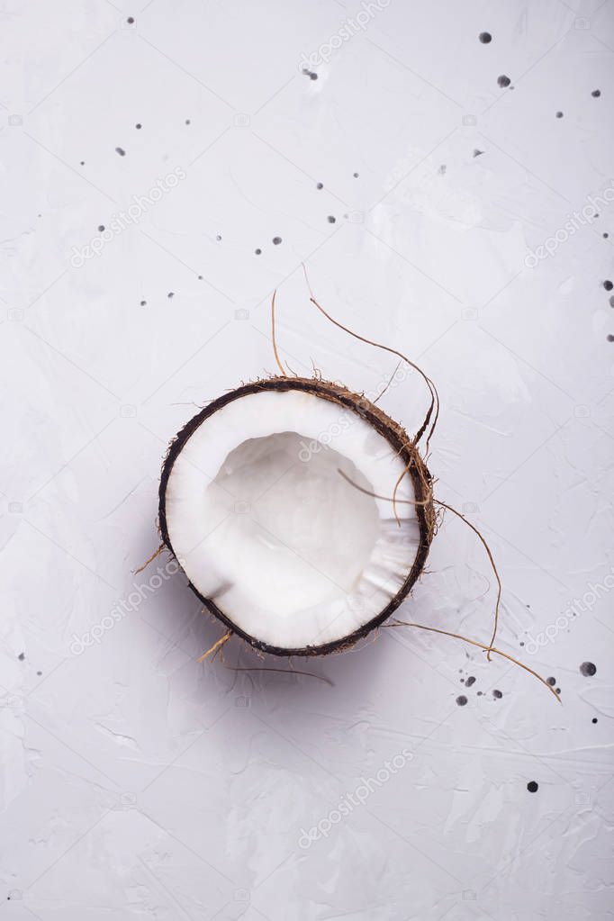 Half a coconut in shell on a gray concrete background