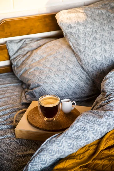 Black coffee in a transparent cup in bed in the autumn morning — Stock Photo, Image