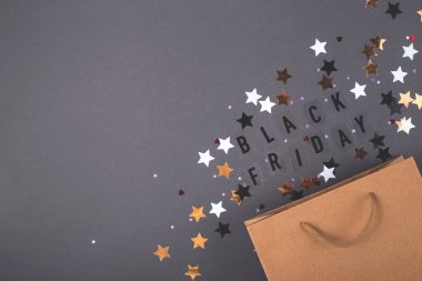 Parlak siyah arka planda Kraft kese kağıdı. Kara Cuma kavramının metniyle.