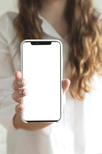 Žena drží a používá smartphone s prázdnou bílou obrazovkou pro design. — Stock fotografie