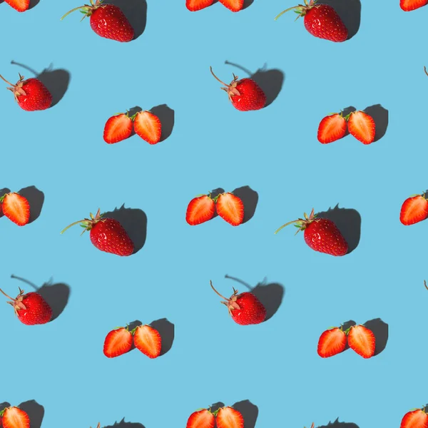Red bright strawberry with shadows on a blue. Seamless pattern