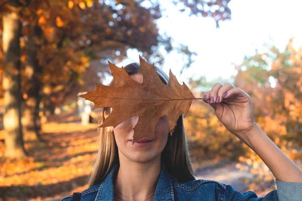 Retrato de mulher de outono com folha de carvalho na mão . — Fotografia de Stock