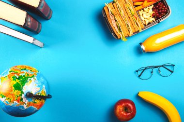 Açık mavi arka planda uygun bir konteynırda sağlıklı bir okul yemeği..