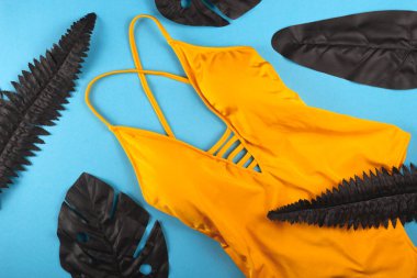 Karşıt siyah yapraklı parlak sarı bir mayo. Düz yatıyordu.