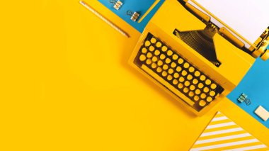 Sarı ve mavi arka planda sarı parlak daktilo. Yazma, blog yazma, yeni fikirler ve yaratıcılık sembolü. Boşluğu kopyala