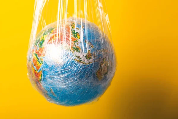 World ocean pollution and planet ecology concept. The globe is wrapped in plastic