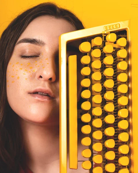 Woman with a typewriter in yellow monochrome. Creative concept — Stock Photo, Image