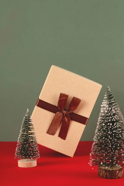Балансирующий рождественский подарок среди елок. — стоковое фото