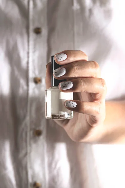 Witte nagellak in een fles en op een vrouwenmanicure — Stockfoto
