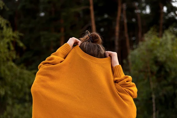 女孩子在大自然中脱下黄色的秋衣 — 图库照片