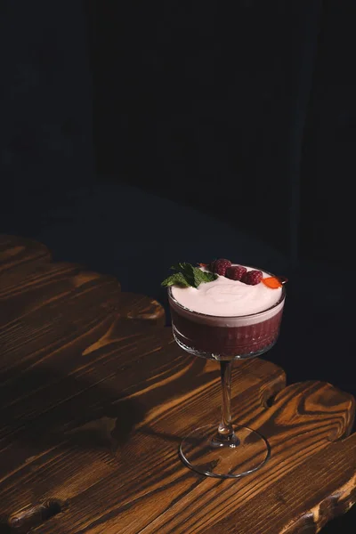 Raspberry cocktail sour in a dark bar on a wooden table — Stock Photo, Image
