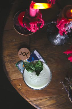 Koyu renkli kırmızı ışıklar arasında taze fesleğen kokteyli.