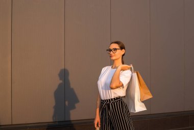 Alışveriş merkezinin önünde alışveriş yapan neşeli kız. 