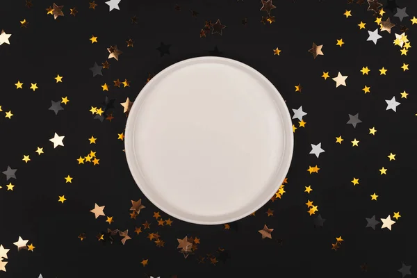 Черный фон с блестящими звездами и пустой тарелкой макет — стоковое фото