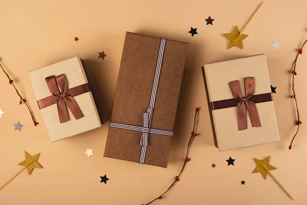 Drie kerst geschenkdozen op een neutrale achtergrond onder decoraties — Stockfoto
