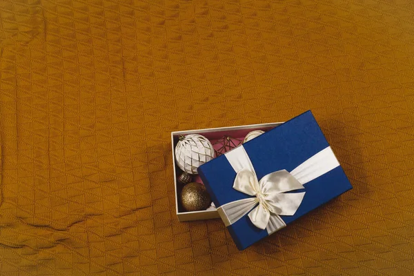 Scatola blu piena di palline bianche e oro decorazioni natalizie — Foto Stock