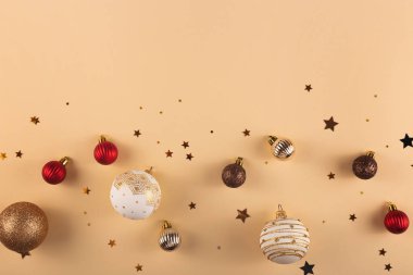 Minimalist yuvarlak Noel, beyaz, kırmızı ve altın renkli toplar yıldızlı tarafsız bir zemin üzerinde. Üst görünüm ve kopyalama alanı