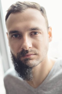 Yakışıklı adam yüzü kirli sakallı yarısı beyaz arka plan önünde yarım sakal ayakta, diğer yarısı güzel bir sahiptir kesilmiş sakalları ve akıllı göz saç stili