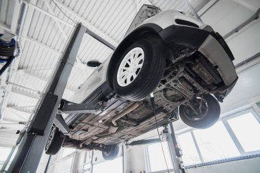 Araba tekerlek hizalama üzerinde asansör otomatik hizmetinde. Asansörde kaldırdı arabanın şasi tanısında.