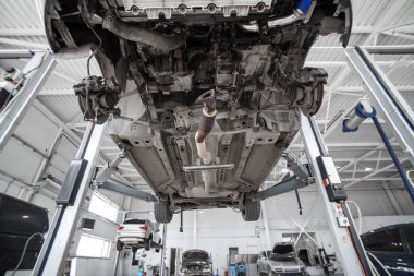 Araba tekerlek hizalama üzerinde asansör otomatik hizmetinde. Asansörde kaldırdı arabanın şasi tanısında.