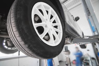 Araba tekerlek hizalama üzerinde asansör otomatik hizmetinde. Asansörde kaldırdı arabanın şasi tanısında.