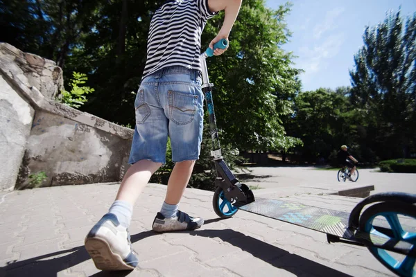 Teenage boy performs a trick on a scooter. Summer fun.