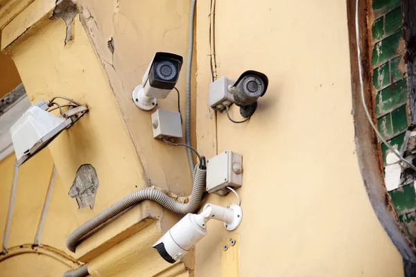 Drie buiten videocamera op een oud beige gebouw — Stockfoto